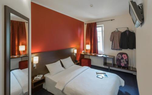 里加杜多酒店的配有一张大床和镜子的酒店客房