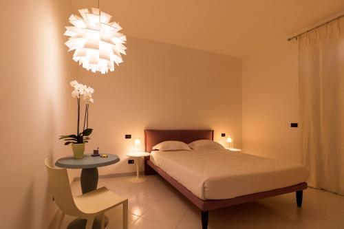 孔韦尔萨诺B&B Casa Laruccia的一间卧室配有一张床、一张桌子和一个吊灯。
