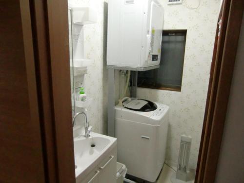 东京海思优斯旅馆的一间带水槽和洗衣机的小浴室