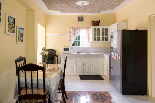 蒙特哥贝Relax in Sunny Montego Bay, Jamaica的厨房配有桌子和冰箱