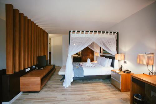 迪沙鲁迪沙鲁海滩桑德及桑德尔斯Spa度假酒店的一间卧室配有一张带天蓬的床