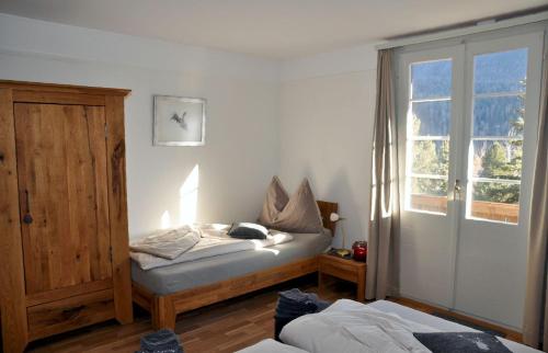 施库尔Chalet Trü的一间卧室配有床、窗户和床罩。