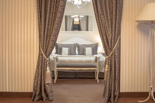 索哈切夫肖邦酒店的一间卧室配有床和椅子及窗帘
