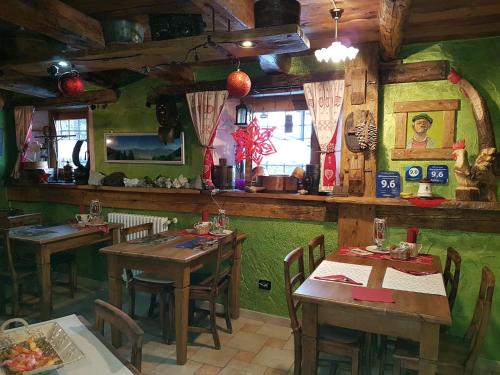 Charvensod赛萨罗德酒店的餐厅设有木桌和绿色的墙壁