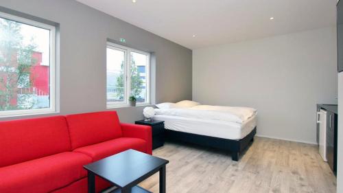 阿克雷里拉瓦公寓的客厅配有红色的沙发和床。