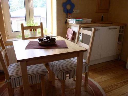 巴特多布兰Ferienwohnung Bad Doberan MOST 2081的厨房里配有一张木桌和椅子