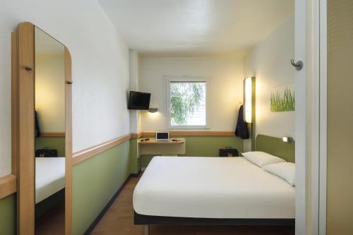 马拉加玛拉咖中心宜必思快捷酒店 的客房设有白色的床和窗户。