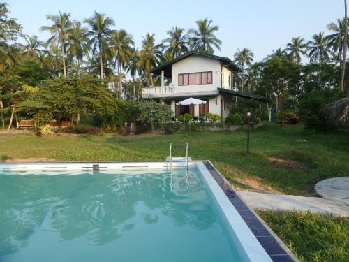 Bandara Koswattacocoworld bungalow的房屋前有游泳池的房子