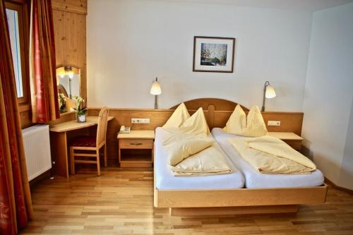 斯拉德明Hotel Druschhof的酒店客房配有一张床、一张书桌和一张书桌。