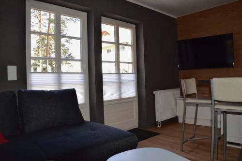 青斯特chalet Zingst的带沙发和桌子的客厅以及2扇窗户。