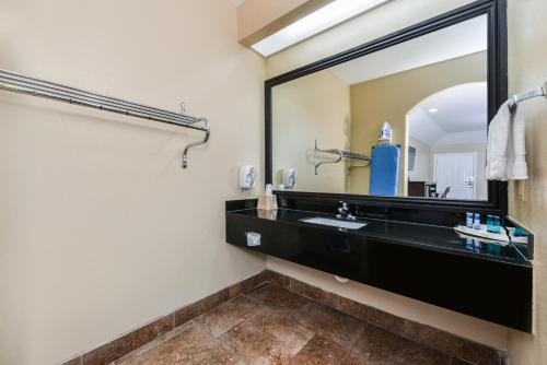 Mission Bend苏格兰南六号公路旅馆及套房的浴室设有黑色水槽和镜子