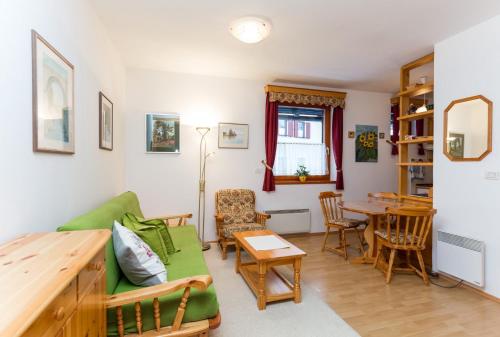 克拉尼斯卡戈拉Apartma Sončnica的客厅配有绿色沙发和桌子