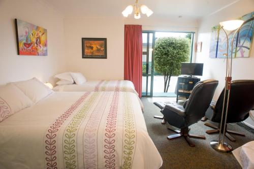 纳皮尔格洛斯特绿草地汽车旅馆的酒店客房,配有一张床、一张桌子和椅子
