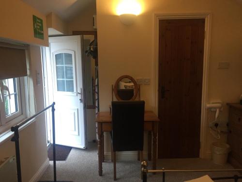 沃辛Findon Rest Ltd的走廊上设有门、桌子和镜子
