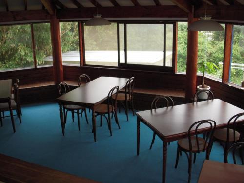 下田逸舒塔图旅馆的用餐室设有桌椅和窗户。