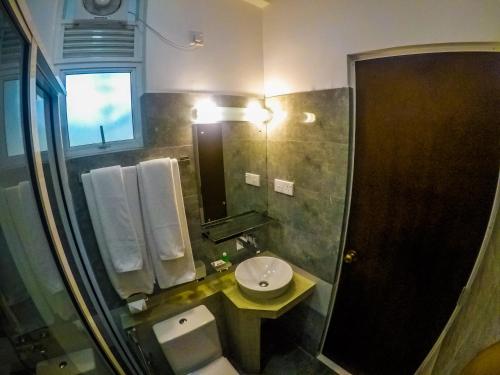康提Chaminrich Homestay的一间带水槽、卫生间和镜子的浴室