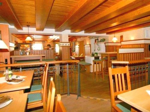 巴特法伊尔恩巴赫凯斯乐威尔特乡村酒店的用餐室配有木桌和椅子