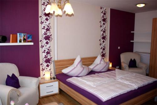 马尔肖Ferienwohnung Malchow SEE 7231的一间卧室配有一张带紫色墙壁和白色枕头的床。