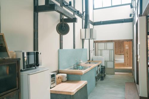 京都京町家旅宿 大雲的一个带水槽的大厨房和一台电视机