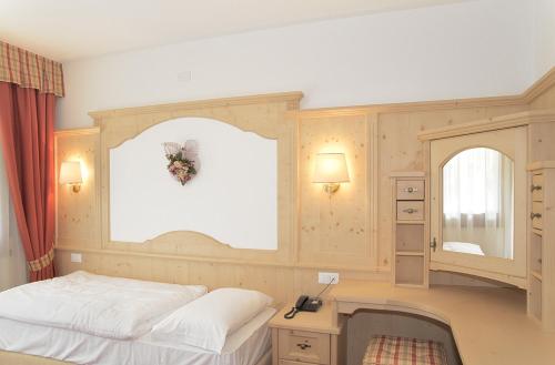 福尔诺迪佐尔多Hotel Garnì posta的一间卧室配有一张床、一张书桌和一个窗户。