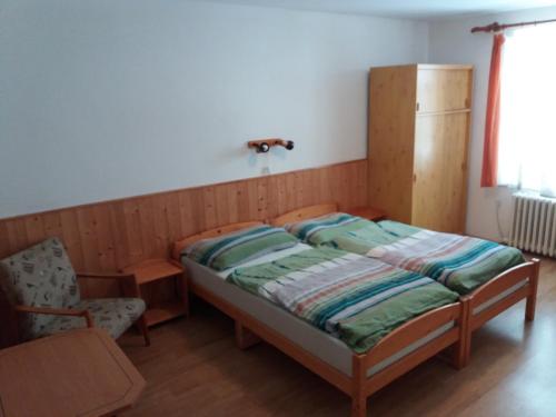 VápennáU Nás - Apartmán Jelen的卧室配有床、椅子和窗户。