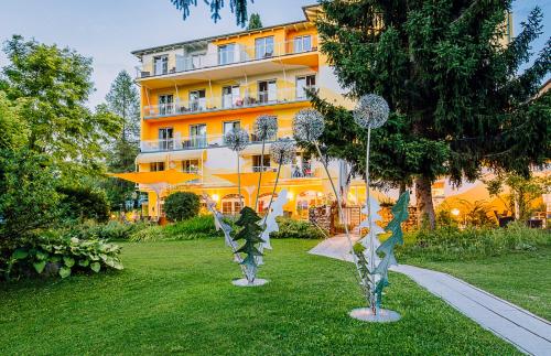 法克湖畔埃格Das Moser - Hotel Garni am See (Adults Only)的建筑物前草上两个金属雕塑