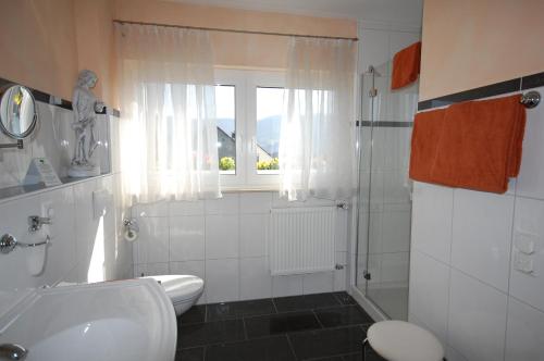 贝尔恩卡斯特尔-库斯Ferienweingut Port的一间带水槽和卫生间的浴室以及窗户。