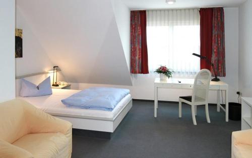 弗尔德莱茵酒店 的一间卧室配有一张床、一张桌子和一把椅子
