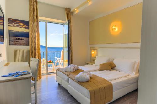 托尔博莱Hotel Lido Blu - Surf & Bike的一间卧室设有一张床,享有海景