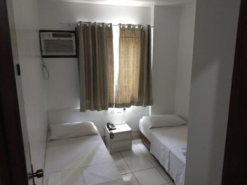 巴拉奈里奥-坎布里乌Master Hotel的小房间设有两张床和窗户
