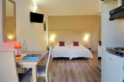 塞雷拉Hotel Stella Marina的一间卧室配有一张床、一张桌子和一张书桌
