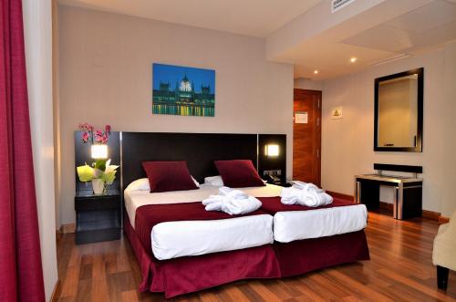 马德里克莱门特巴拉哈斯酒店的酒店客房,配有两张带毛巾的床