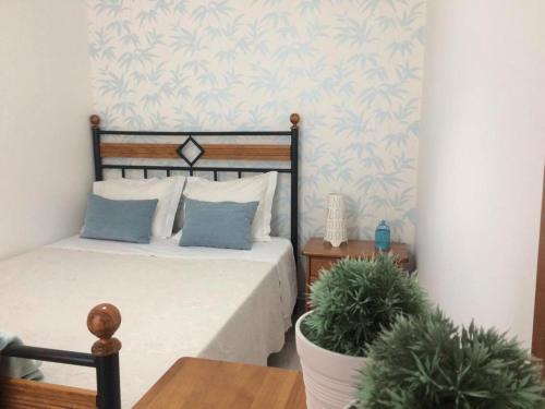纳扎雷Casa BeijoMar的一间卧室配有一张床和盆栽植物