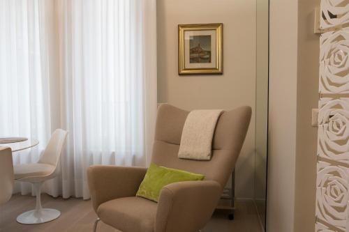 米兰Milano Porta Venezia Suite Centro的客厅配有带绿色枕头的椅子