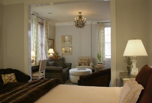夏洛茨维尔Inn at Court Square的一间带一张床的客厅和一间带沙发的客厅