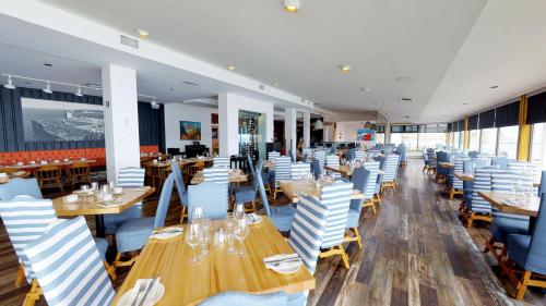 佩尔塞佩尔塞利奥特尔酒店的餐厅设有木桌和蓝色椅子