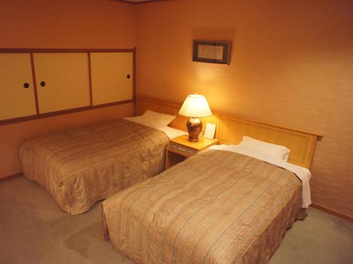 岐阜杉山旅馆的酒店客房,设有两张床和一盏灯