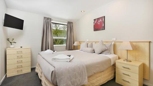 基督城亚瑟苑汽车旅馆的一间卧室设有一张大床和一个窗户。