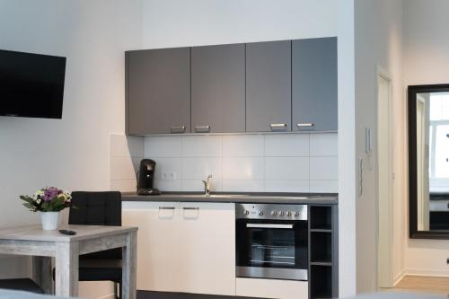 吉森Appartement am Schloss的厨房配有黑白橱柜和桌子