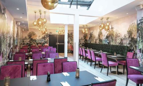 奥斯陆松恩酒店的一间用餐室,配有紫色的椅子和桌子