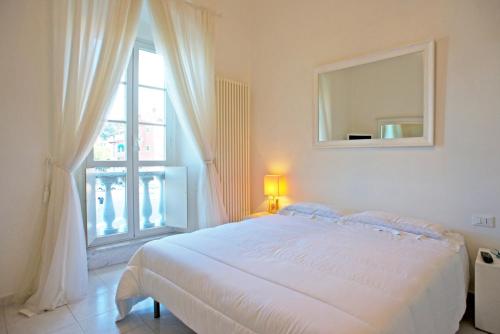 莱里奇Vittoria的白色的卧室设有一张大床和一个窗户