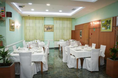 Prelog寇吉酒店的用餐室配有白色的桌子和白色的椅子