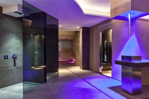 卡塞勒蒂索玛坎普Hotel Saccardi & Spa - Adults Only的建筑中带紫色照明的走廊