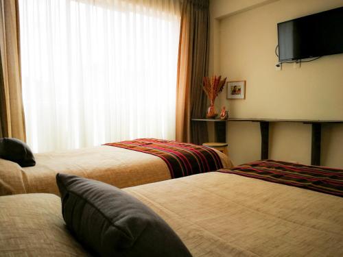 拉巴斯萨迦纳迦酒店的酒店客房设有两张床和一台平面电视。