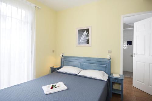 居让梅斯特拉Résidence Prestige Odalys Les Greens du Bassin的一间卧室配有一张蓝色的床,上面有托盘