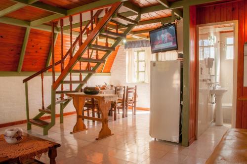 圣马丁德洛斯Apart Hotel Ensueño的厨房设有楼梯、桌子和冰箱。