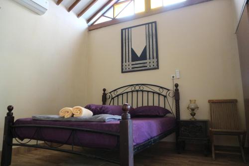 日惹肯巴尔住宿加早餐旅馆的一间卧室配有一张紫色床单的床