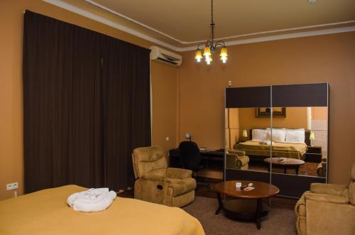 帕拉马里博舍瓦酒店的酒店客房带两张床和一张桌子以及椅子。