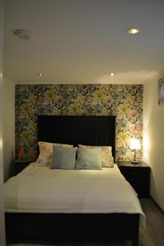 埃因霍温Suite 17的一间卧室设有一张带花卉墙壁的大床