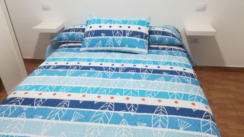 阿里纳加Apartamento Quintana的蓝色的床,配有蓝色和白色的床单和枕头